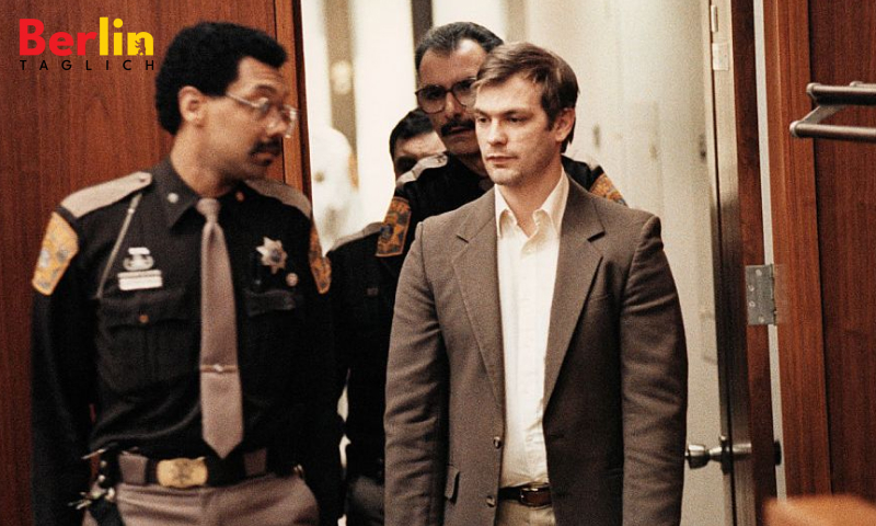 Jeffrey Dahmer, der eine hellbraune Anzugsjacke und ein weißes Hemd trägt, wird von drei uniformierten Polizeibeamten in einen Gerichtssaal begleitet Quelle: Getty Images